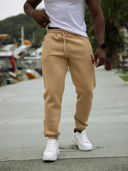 Pantalón de chándal L.A. de algodón y poliéster, diseño cómodo con puños en los tobillos, estilo deportivo y urbano en color beige