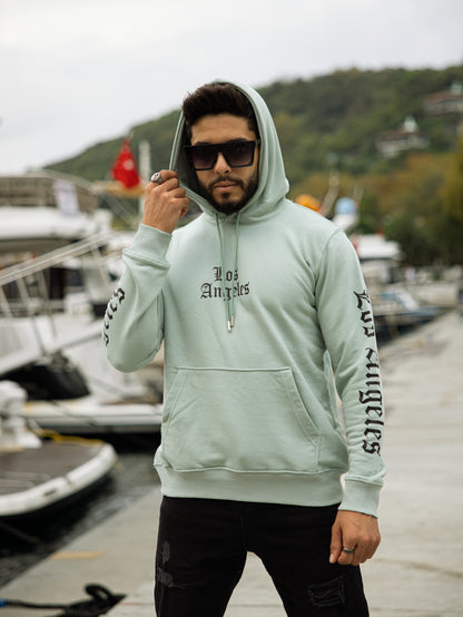 Sudadera con capucha 100% algodón, corte regular fit, diseño Los Angeles, estilo casual y cómodo, perfecta para el día a día. Color verde agua.