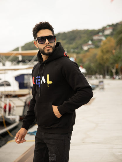 Sudadera con capucha de algodón y poliéster en corte regular fit, modelo Real. Ideal para un look casual y cómodo.