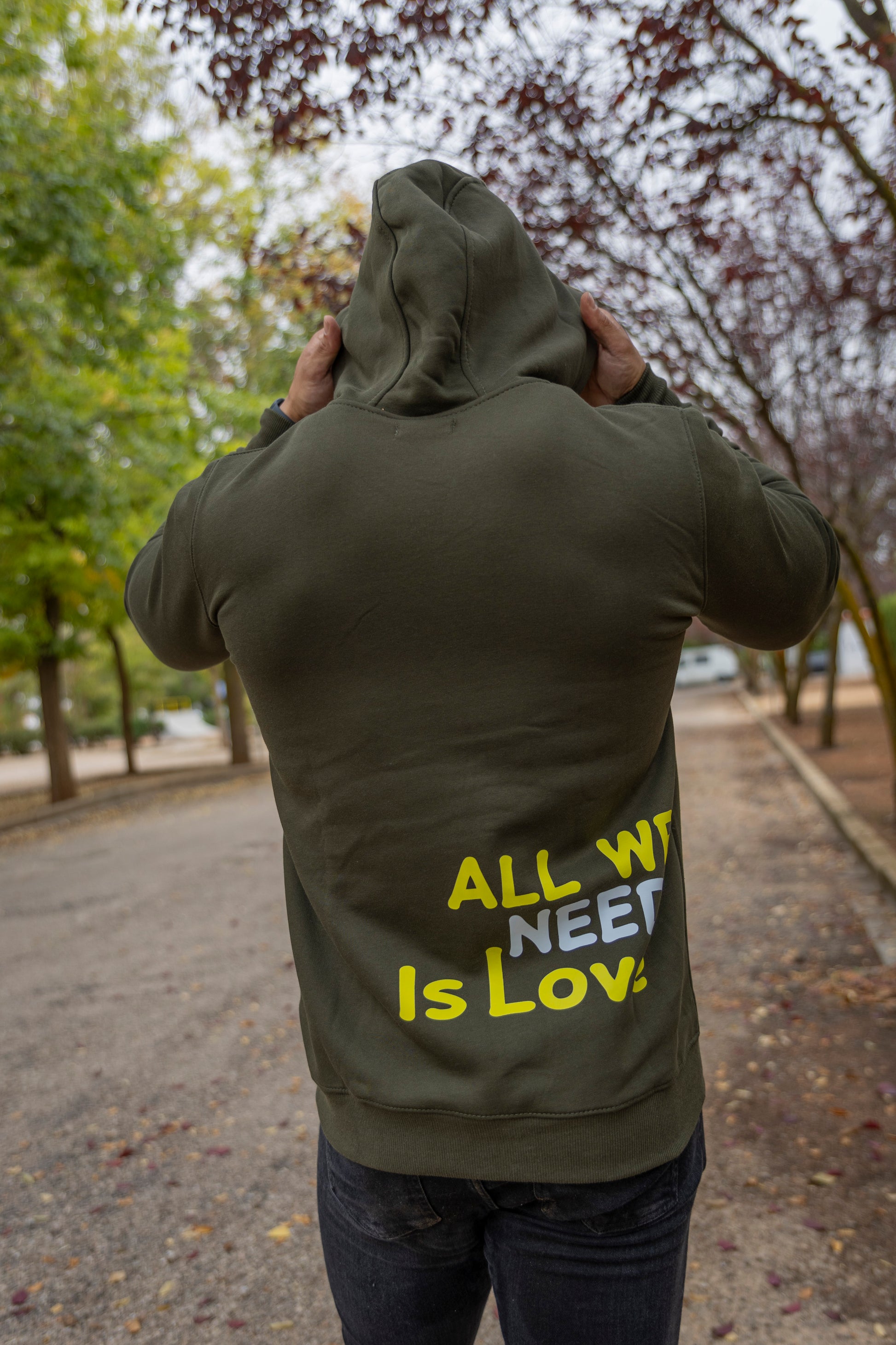 Sudadera con capucha, bolsillos y cremallera de algodón y poliéster con diseño "All We Need Is Love" en color kaki. Ideal para un look casual y cómodo.