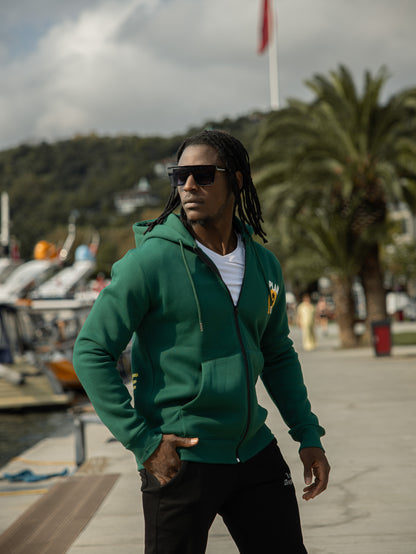 Sudadera con capucha, bolsillos y cremallera de algodón y poliéster con diseño "All We Need Is Love" en color verde. Ideal para un look casual y cómodo.